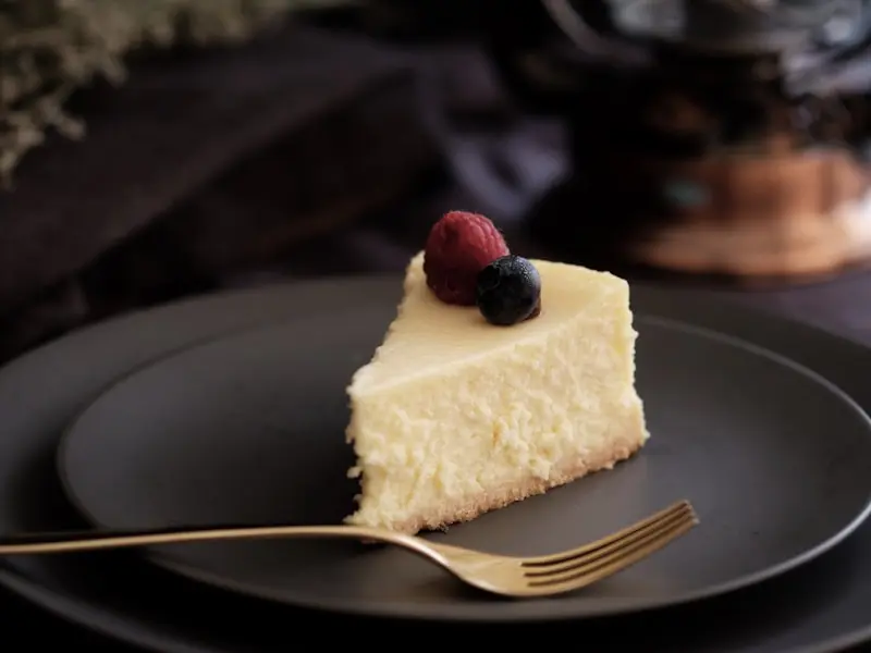 Slice of creamy New York cheesecake with berry topping